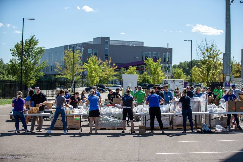 Polaris volunteers form assembly line to pack meal bags