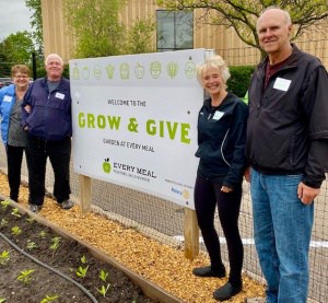Sue and Dan Lehrer and Wendy and Kent Dorholt in front of Grow & Give Garden