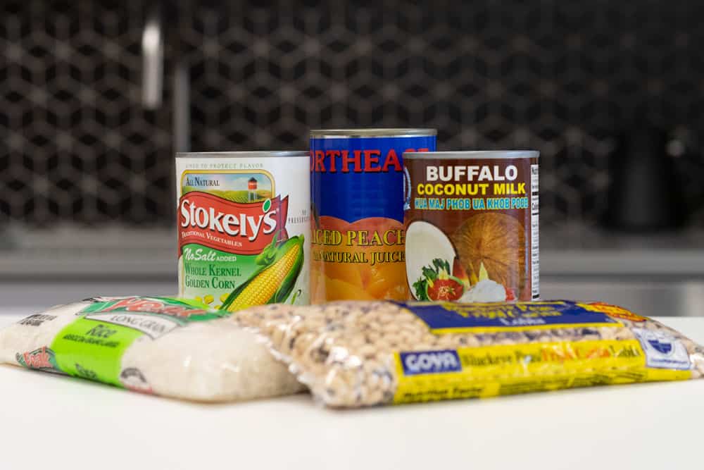 Give Food - Blue Bag Example Foods - Three cans of food and two bags sitting on a counter top