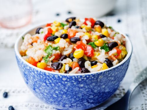 Bowl with rice, beans, corn, and diced tomatoes